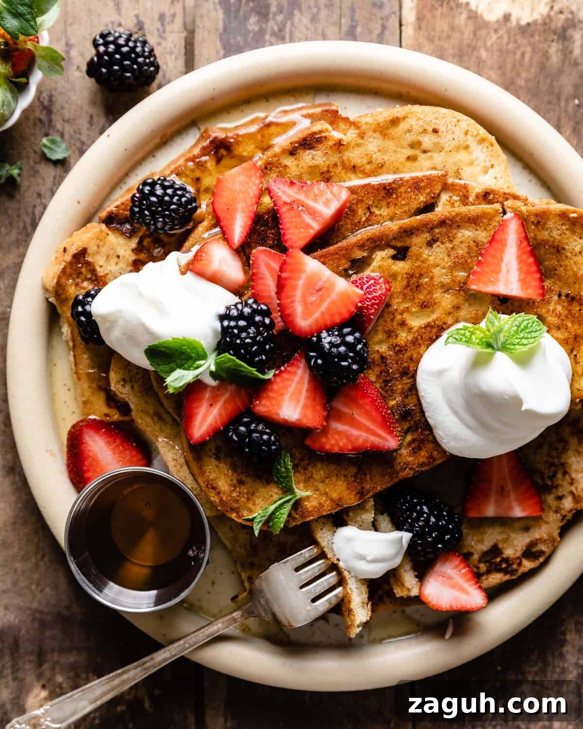 Sourdough French Toast Recipe with Crispy Edges and Custardy Center 2 Sourdough french toast on a white plate.