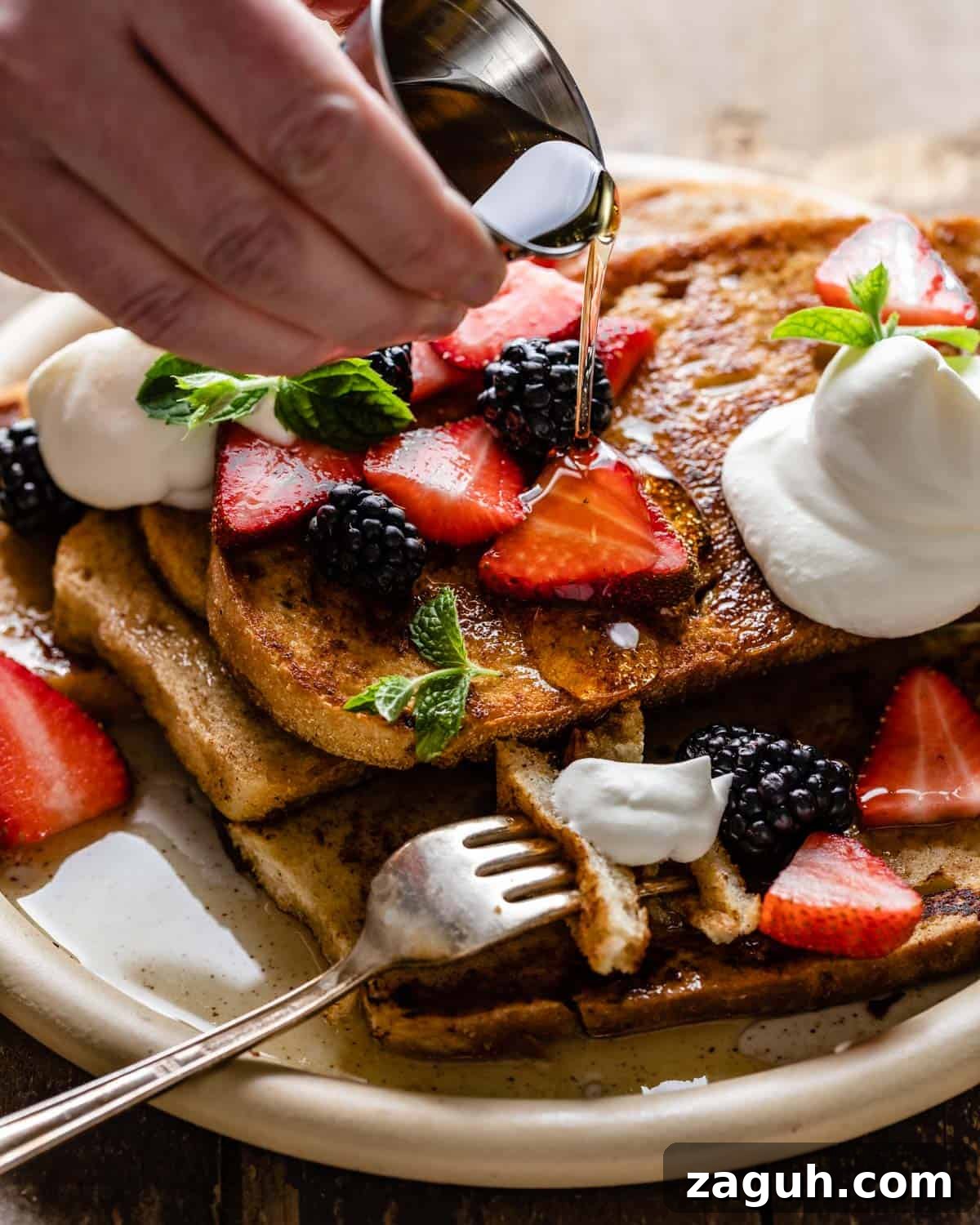 Sourdough French Toast Recipe with Crispy Edges and Custardy Center 7 Sourdough french toast stacked with cream and berries.