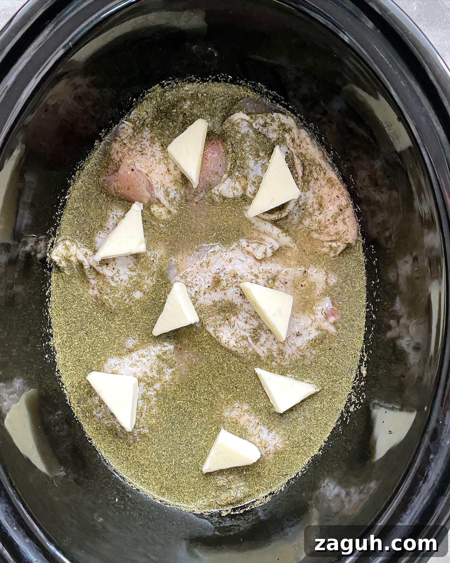 Creamy Lemon Dill Chicken for Slow Cooker: Tender, Flavorful Meal 4 overhead shot of uncooked creamy lemon dill chicken in a black slow cooker