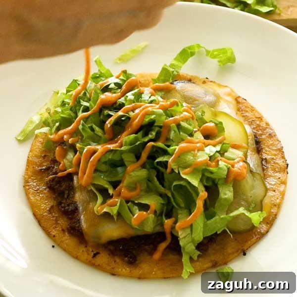 Gluten-Free Big Mac Smashed Tacos Recipe That Went Viral 13 An assembled Big Mac taco topped with shredded lettuce and big mac sauce.