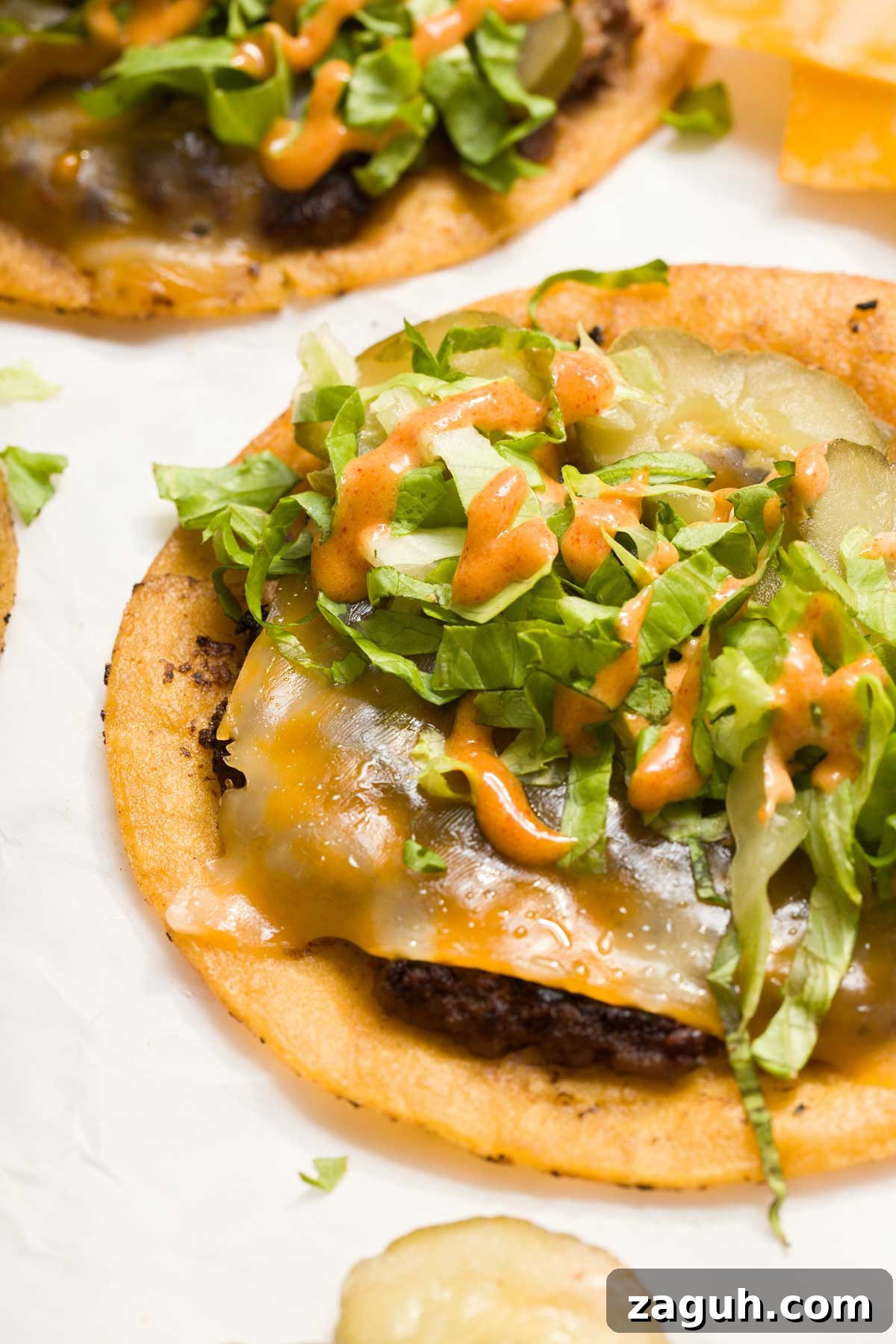 Gluten-Free Big Mac Smashed Tacos Recipe That Went Viral 4 Close up of a big mac taco with cheese, lettuce, and sauce on top.