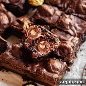 Ferrero Rocher Chocolate Brownies Recipe: Decadent Hazelnut Treat 20 Broken open Ferrero rocher brownie laying on top of cut brownies.