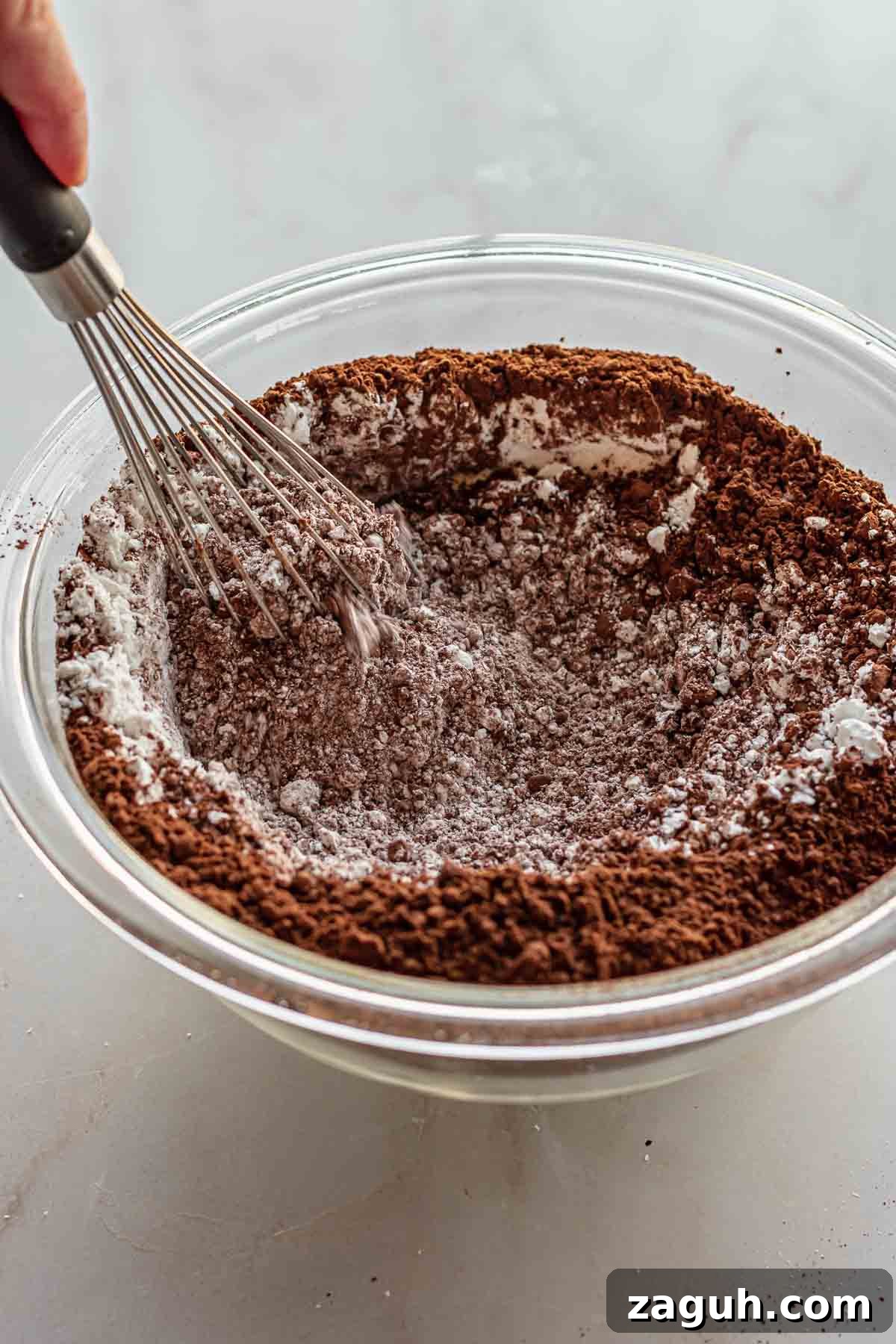 Ferrero Rocher Chocolate Brownies Recipe: Decadent Hazelnut Treat 6 Dry ingredients in a bowl with a whisk.