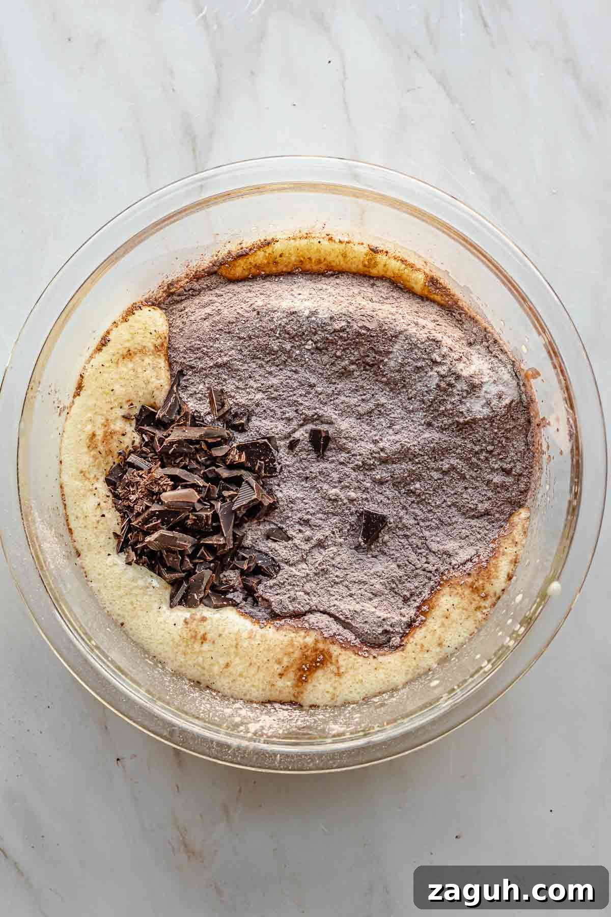 Ferrero Rocher Chocolate Brownies Recipe: Decadent Hazelnut Treat 9 Dry ingredients and chopped chocolate in a bowl with wet ingredients.