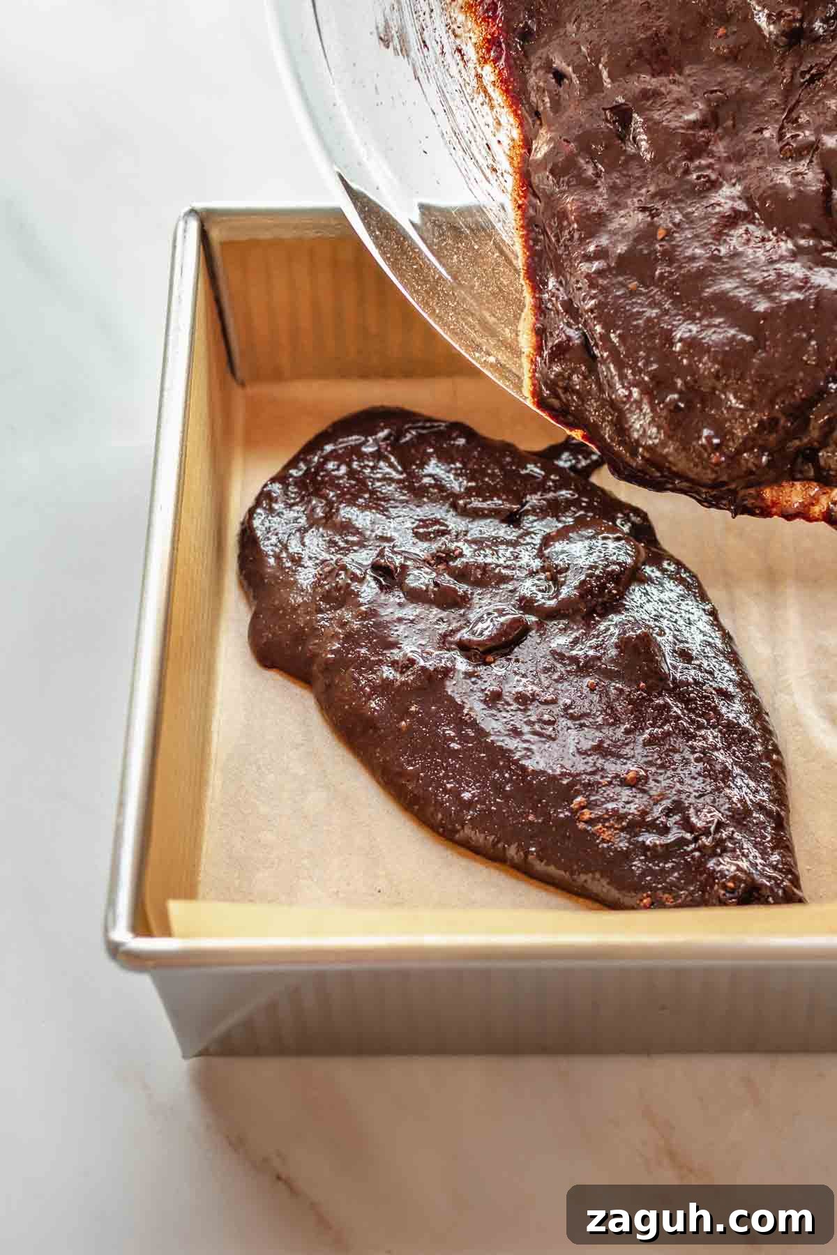 Ferrero Rocher Chocolate Brownies Recipe: Decadent Hazelnut Treat 11 Brownie batter pouring into a prepared pan.