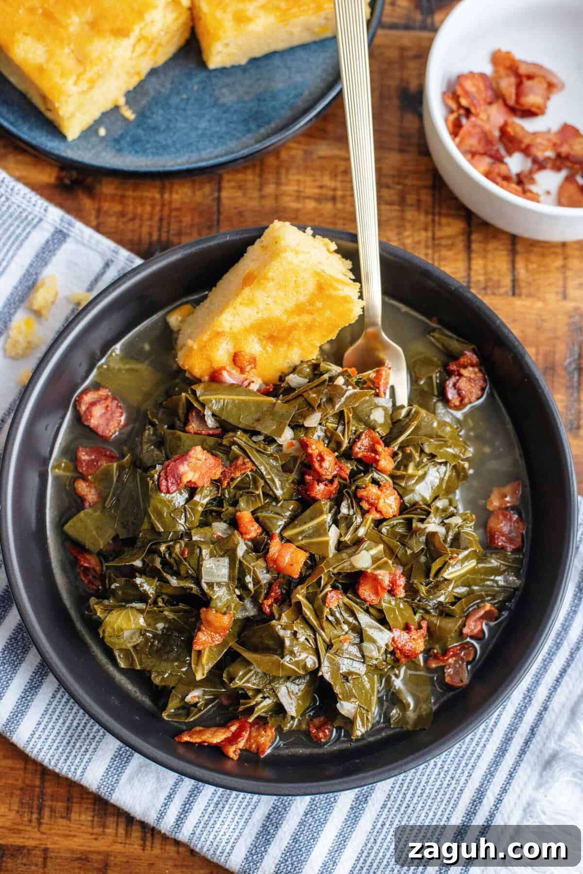 Authentic Southern Collard Greens Recipe That Melts in Your Mouth 17 A serving of collard greens in a black bowl with bacon and cornbread.