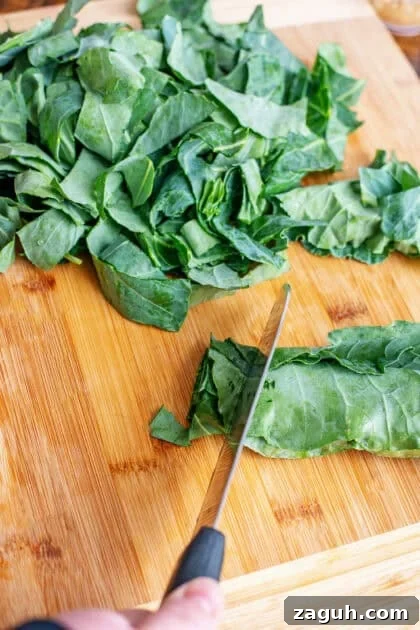 Authentic Southern Collard Greens Recipe That Melts in Your Mouth 6 Chopping collard greens on a wooden cutting board.