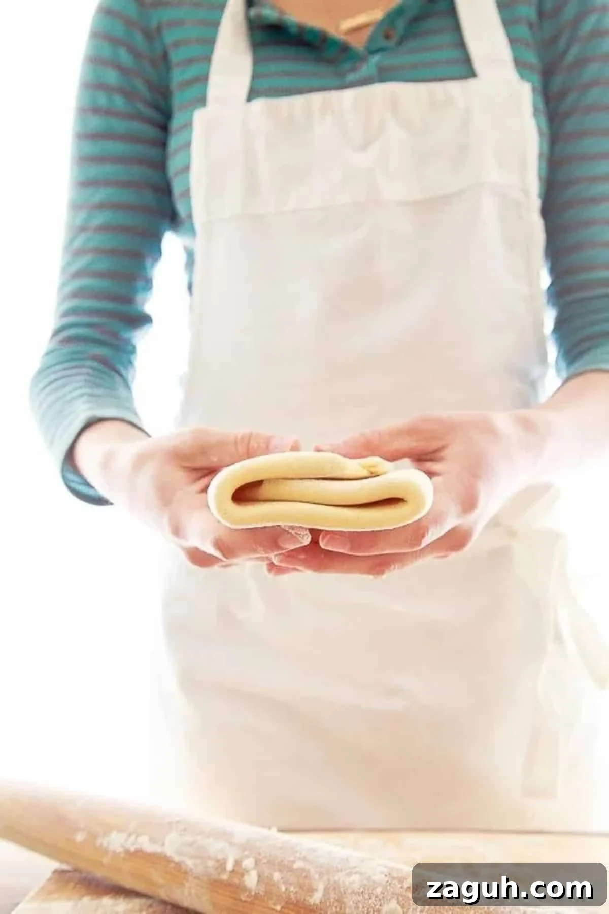 Perfect Puff Pastry Dough: Step-by-Step Homemade Recipe 2 Woman in apron holding folded homemade puff pastry recipes.
