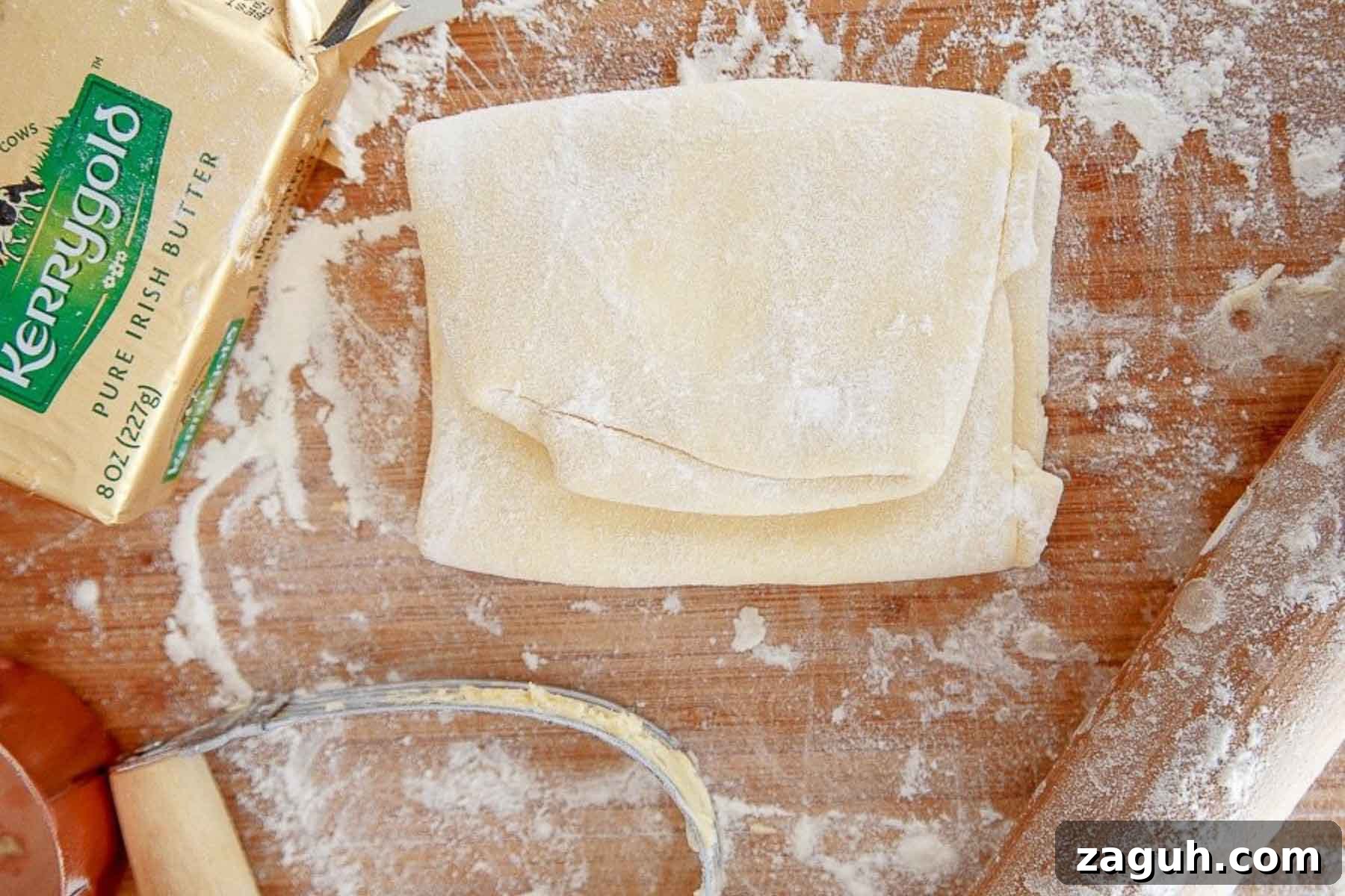 Perfect Puff Pastry Dough: Step-by-Step Homemade Recipe 3 Sheet of homemade puff pastry recipe folded up with butter and pastry blender on side.