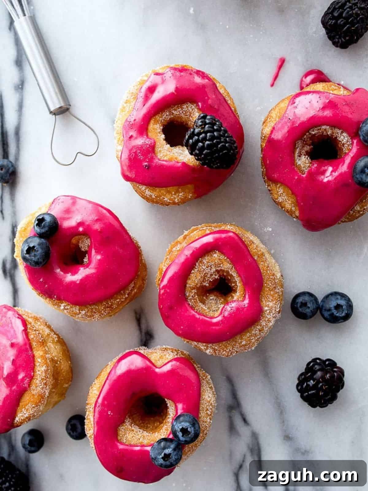 Perfect Puff Pastry Dough: Step-by-Step Homemade Recipe 9 Hot pink donuts decorated with fresh berries on a marble board.