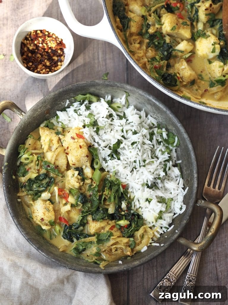 Quick Coconut Fish Curry with Lemongrass and Lime 3 A metal serving dish of cod curry with coriander rice next to a bowl of dried chilli flakes.